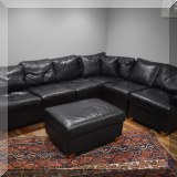 F14. Black leather sectional and ottoman 116” x 94” x 40” ottoman 17”h x 33”w x 26”d 